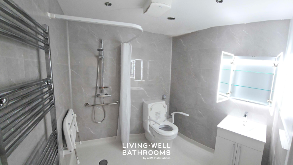 A wet room with curtain rail, toilet, shower seat and gray marble panel walls