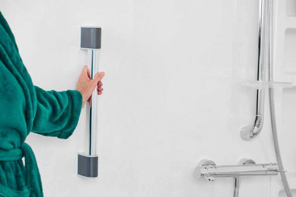 lady in dressing gown grabbing onto a chrome grab bar