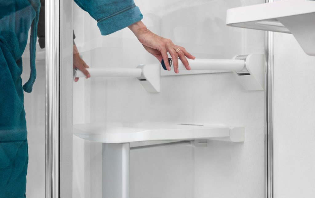 lady's hands using a drop down shower seat