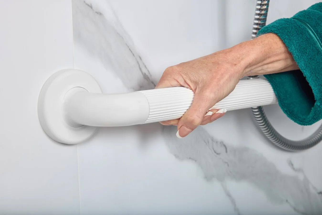 Person holding a grab rail beside an Essential Care low-level walk-in shower