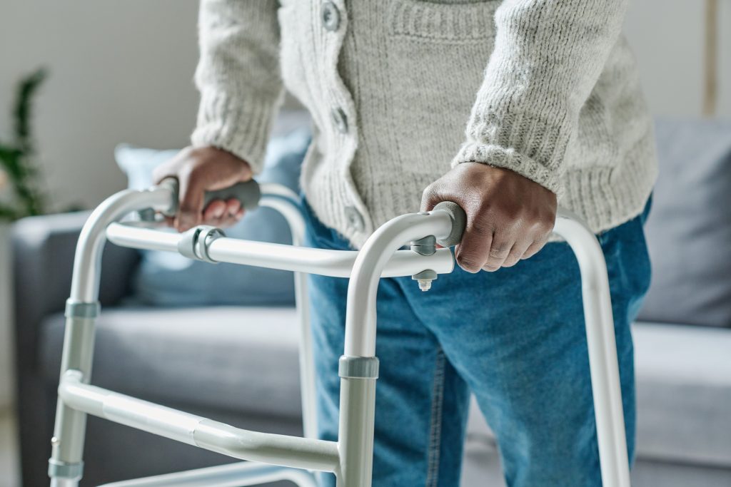 mans hands holding onto a walking frame